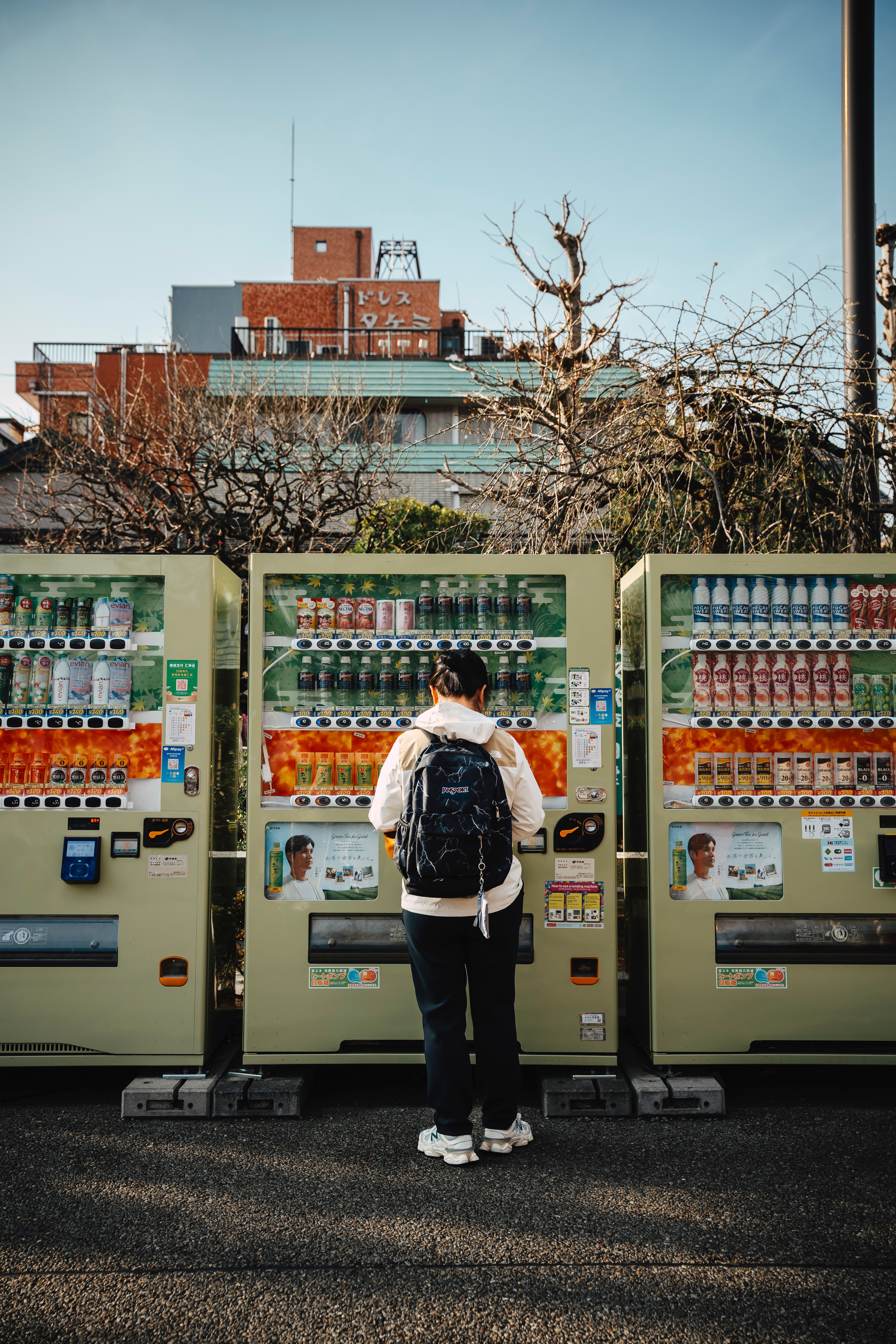 Person Using Vending Machines in Tokyo Street Scene · Free Stock Photo