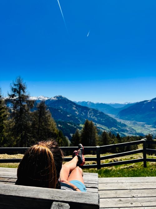 Free A person relaxes while enjoying a stunning mountain view, perfect for travel inspiration. Stock Photo