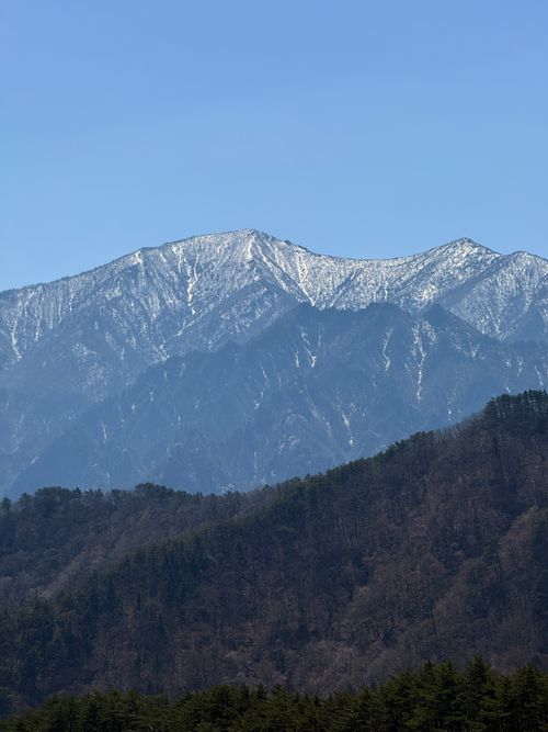 Free A breathtaking view of a snow-capped mountain range under a clear blue sky, perfect for nature enthusiasts. Stock Photo
