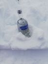 一瓶优质伏特加静置于新鲜雪中，更显其冷酷与纯粹