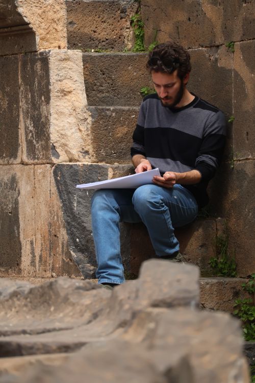 Free Artist engrossed in sketching ancient architecture outdoors, capturing cultural heritage. Stock Photo