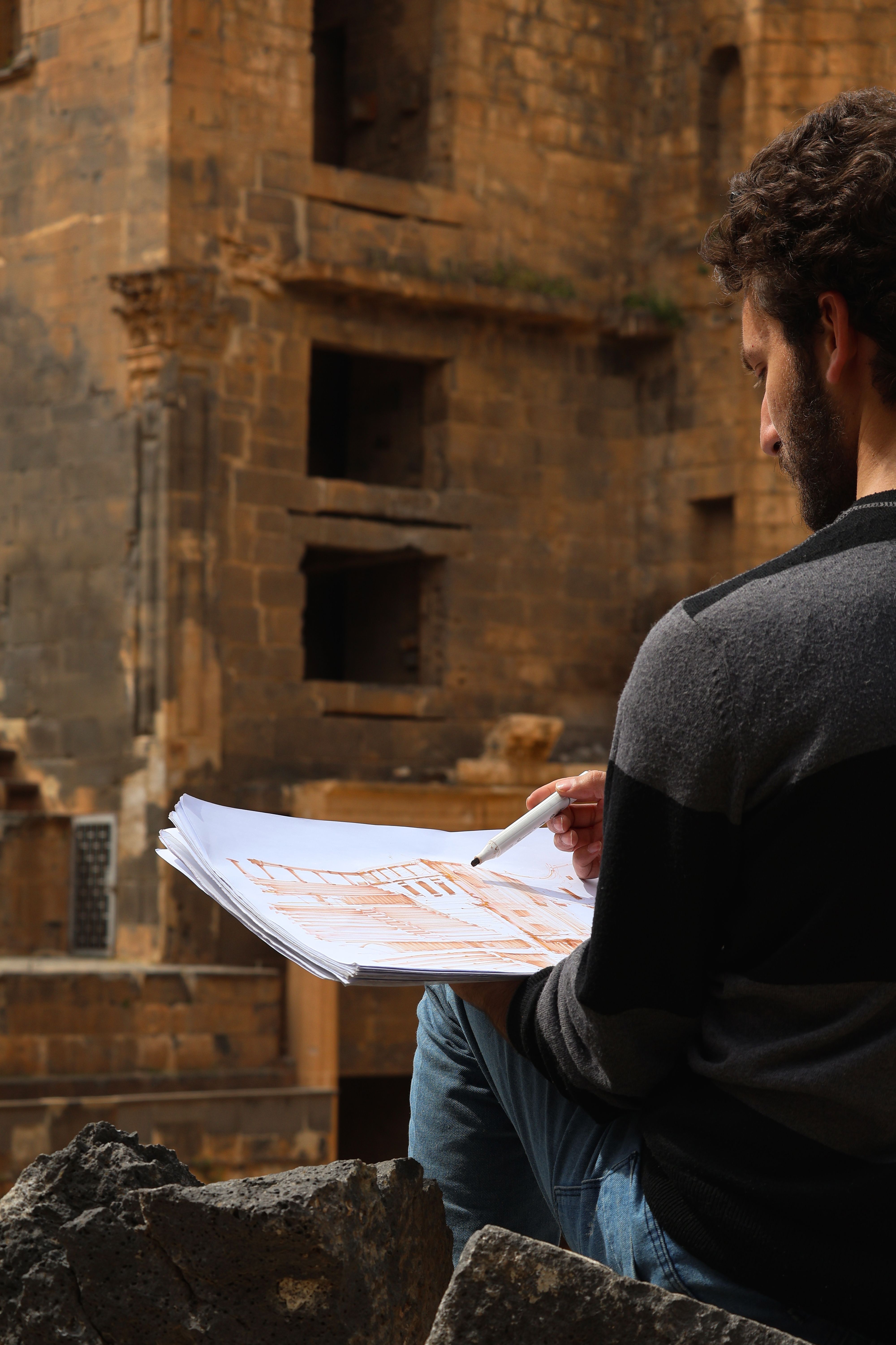 Artist captures historic architecture through sketching, embodying cultural creativity.