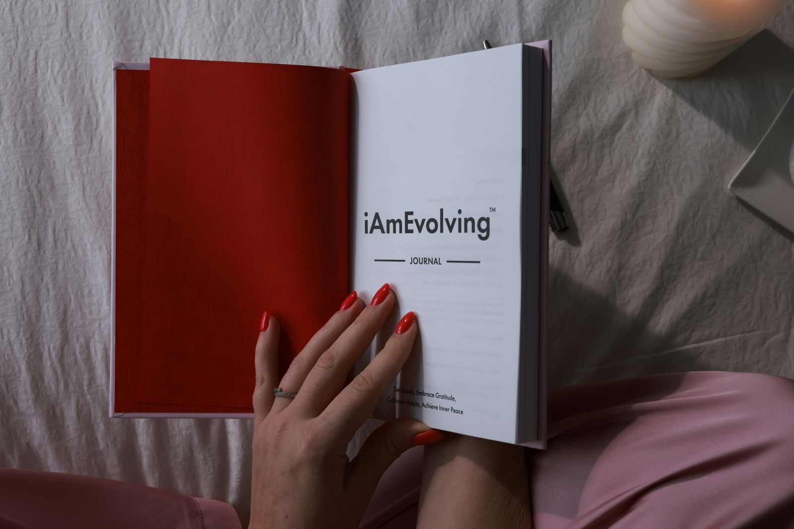 Capture your personal growth journey in a cozy setting with red accented nails.