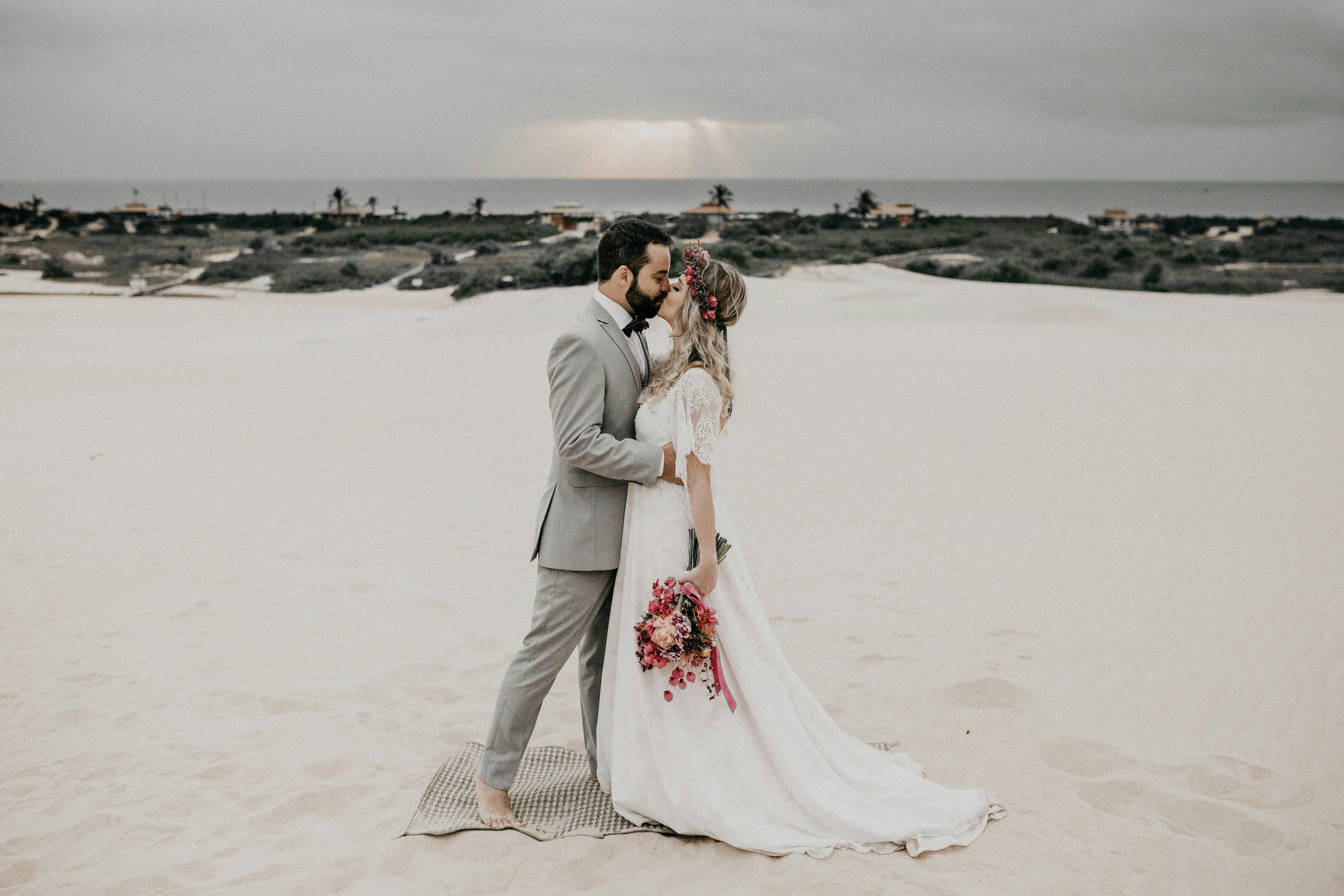 man and woman kissing on beach