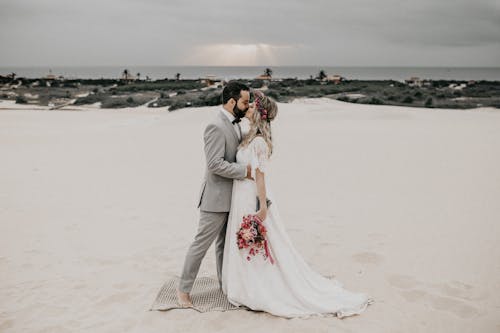 Free Man and Woman Kissing on Beach Stock Photo