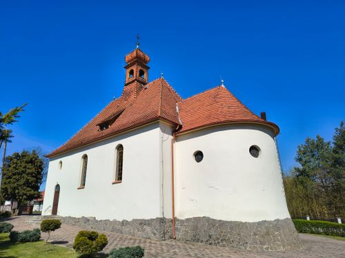 Free Charming village church in Poland with red roof against clear blue sky, showcasing traditional architecture. Stock Photo