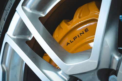 Free Detailed view of a vibrant yellow brake caliper on a supercar wheel, highlighting automotive engineering. Stock Photo