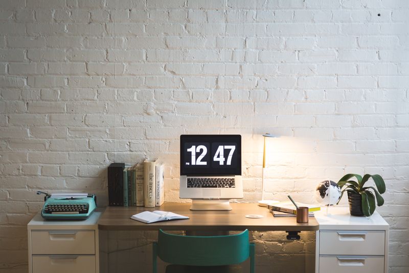 small corkboard with postcards pinned above a desk