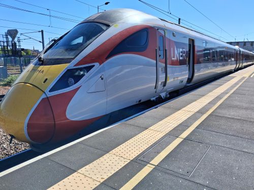 Free A sleek LNER train waits at a sunny station, showcasing modern rail travel in the UK. Stock Photo