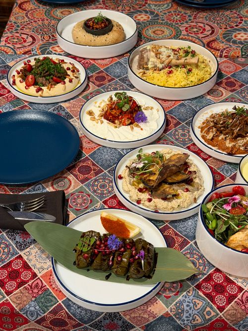 Free Colorful Middle Eastern feast featuring a variety of traditional dishes on a patterned tablecloth. Stock Photo