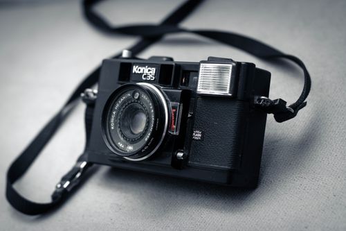 Free Classic Konica C35 film camera with a strap, showcasing retro design and antique charm. Stock Photo