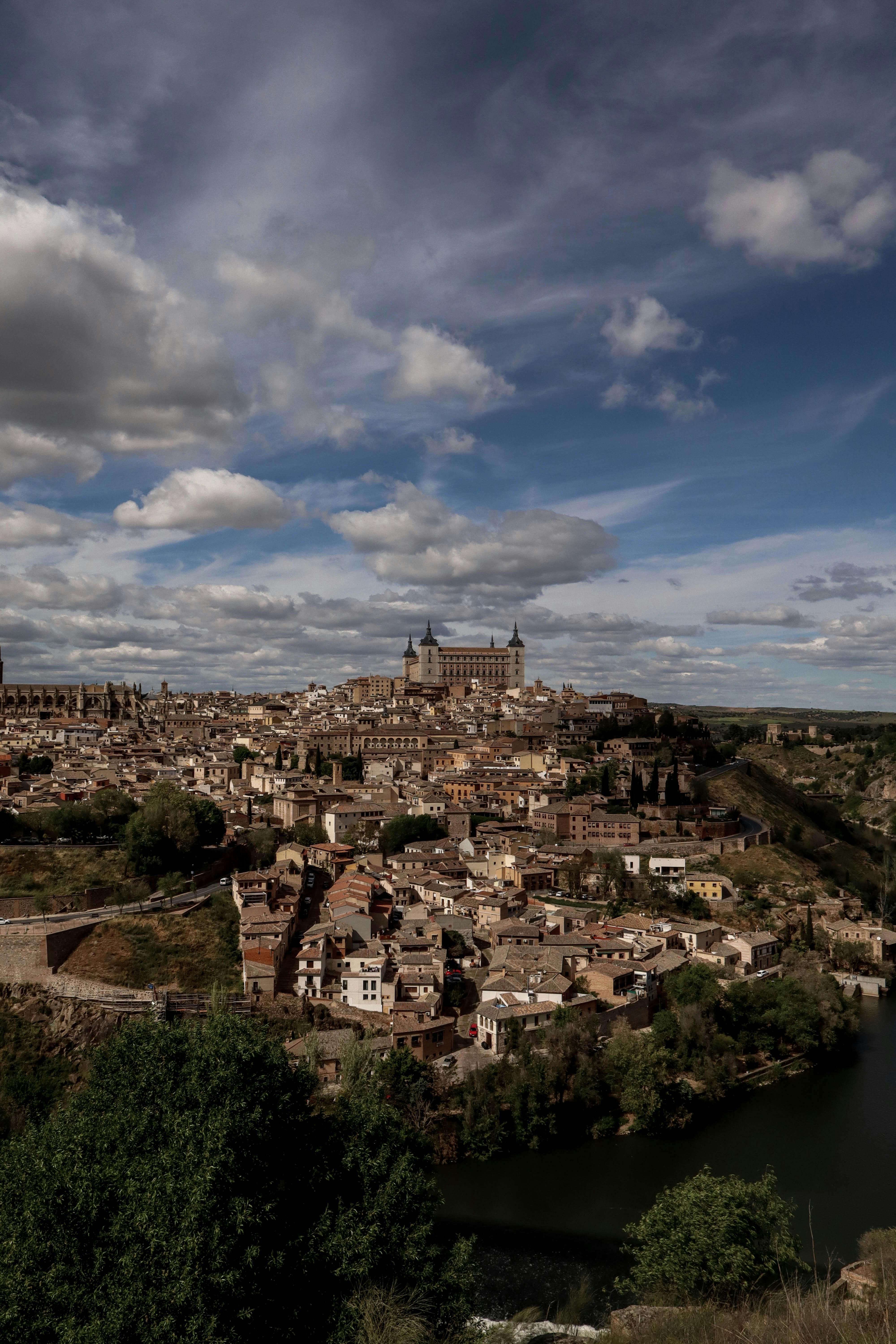 Stunning aerial view of Toledo, Spain showcasing the historic Alcázar under a vibrant blue sky.