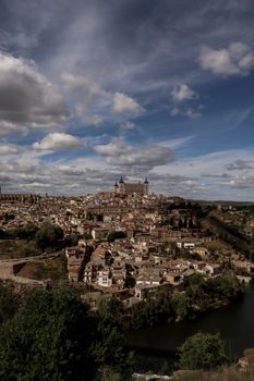 Stunning aerial view of Toledo, Spain showcasing the historic Alcázar under a vibrant blue sky.