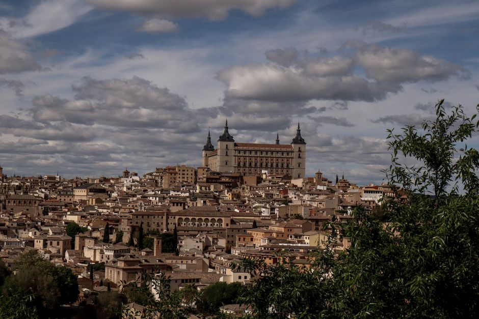 Hermosa vista panorámica de Toledo, España, con el histórico castillo del Alcázar bajo un cielo nublado.