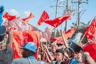 在色彩缤纷的街头游行中，人们挥舞着红旗，在户外庆祝