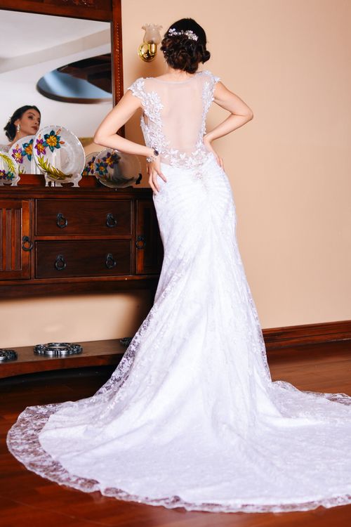 Free Elegant bride in lace wedding gown with reflection in ornate mirror, preparing indoors. Stock Photo