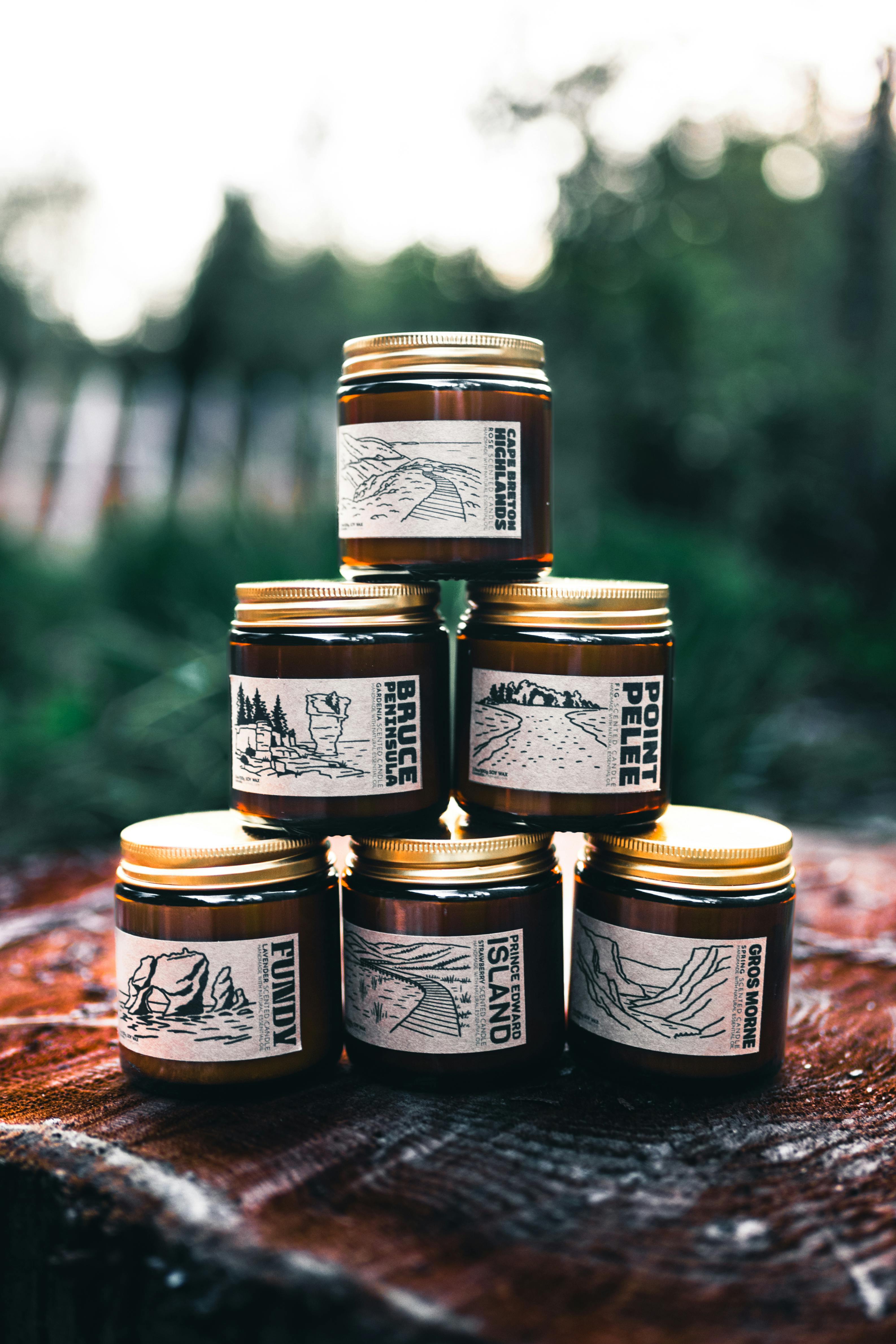 Aesthetic artisanal jars stacked on a tree stump in a forest setting, perfect for nature themes.