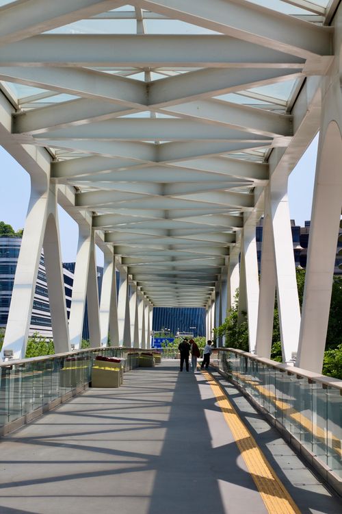 Free A contemporary pedestrian bridge with a unique geometric design, captured on a sunny day. Stock Photo