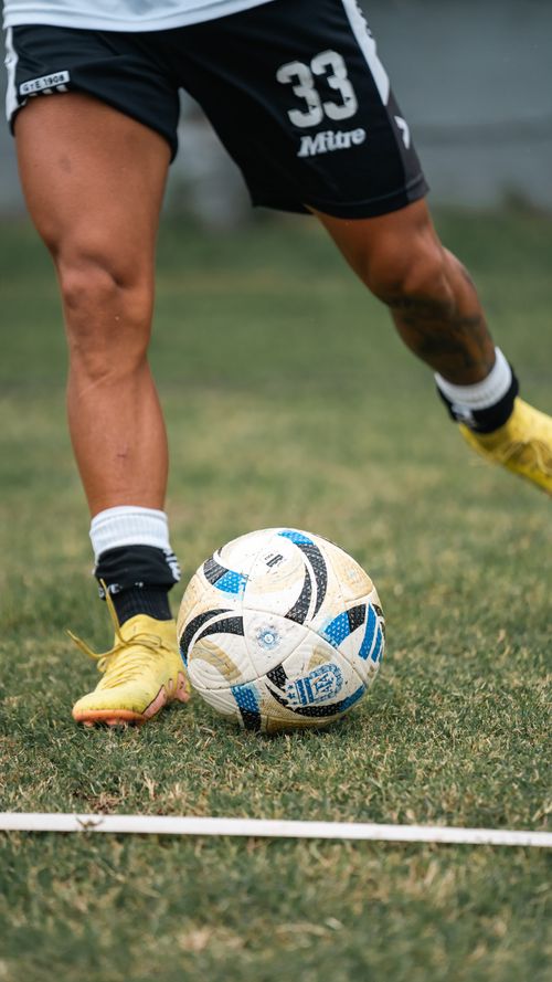 Free Athlete practicing soccer with a ball on green grass field during the day. Stock Photo