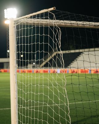 Floodlit goal net at night — photo by Franco Monsalvo on Pexels