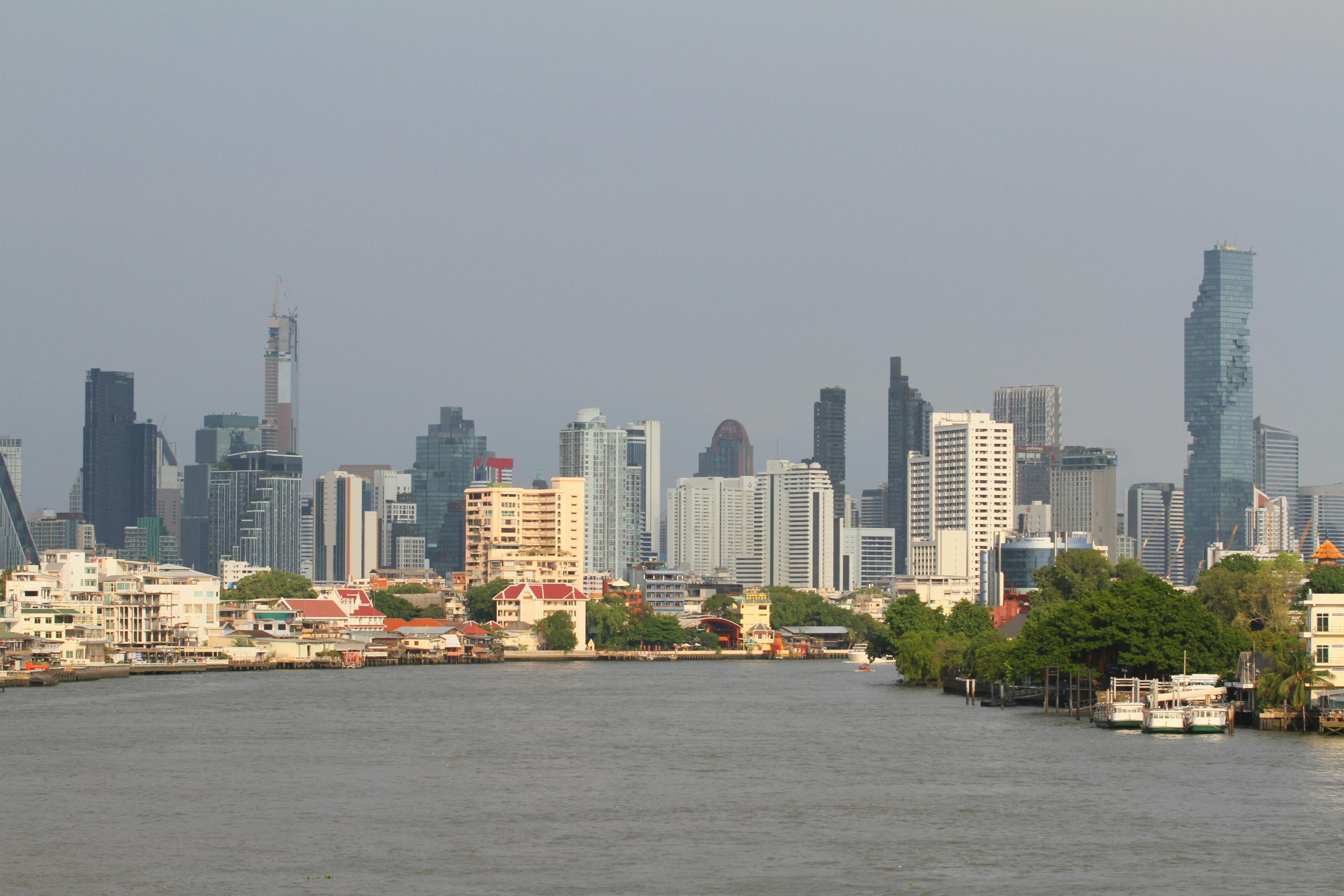 Bangkok's skyline with modern skyscrapers along the Chao Phraya River.
