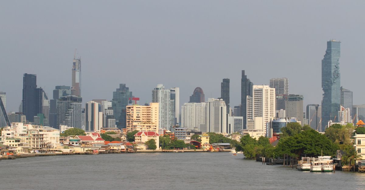 Bangkok's skyline with modern skyscrapers along the Chao Phraya River.
