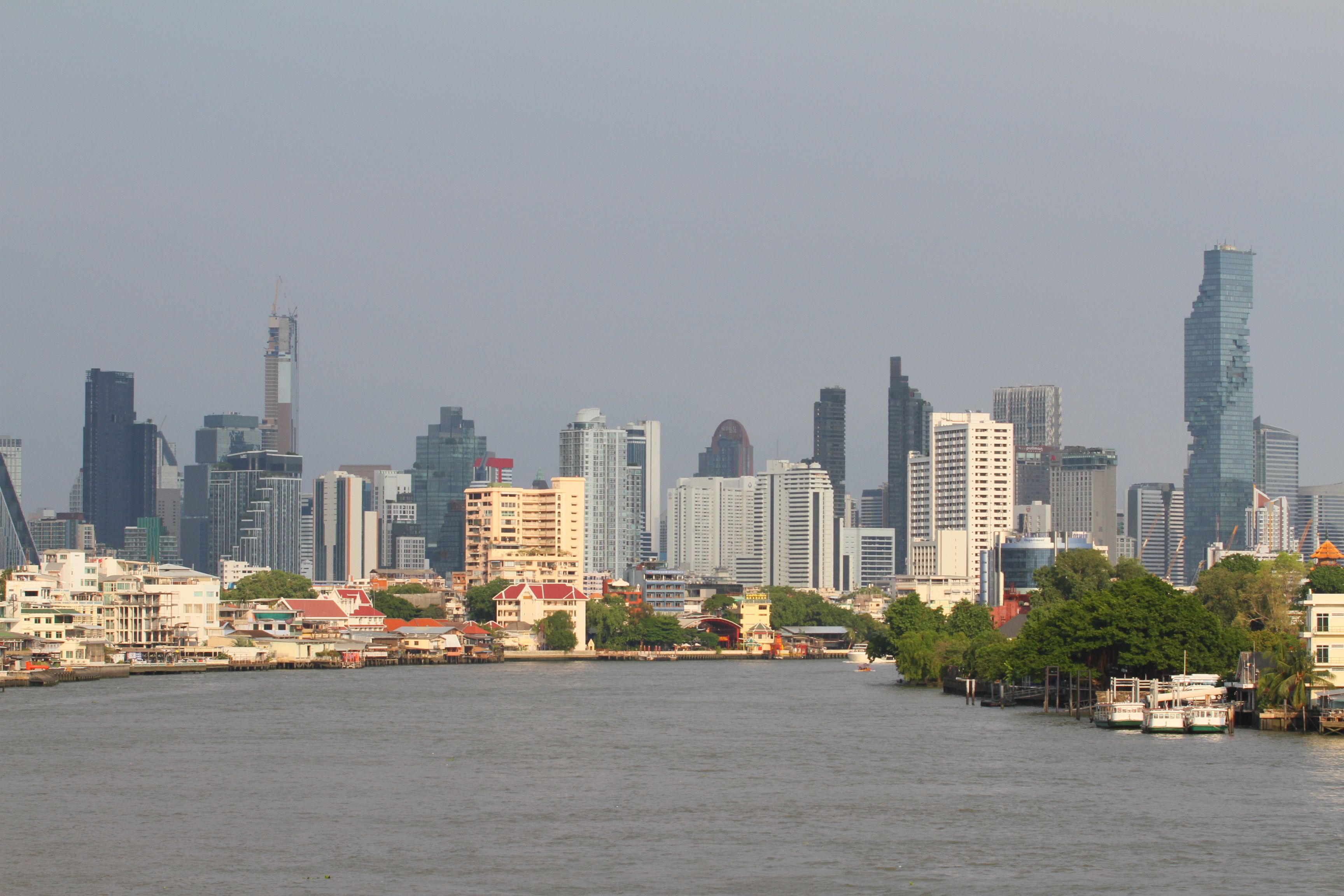 Bangkok's skyline with modern skyscrapers along the Chao Phraya River.