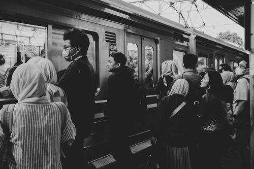 Free Black and white photo of commuters boarding a train at a busy station. Stock Photo