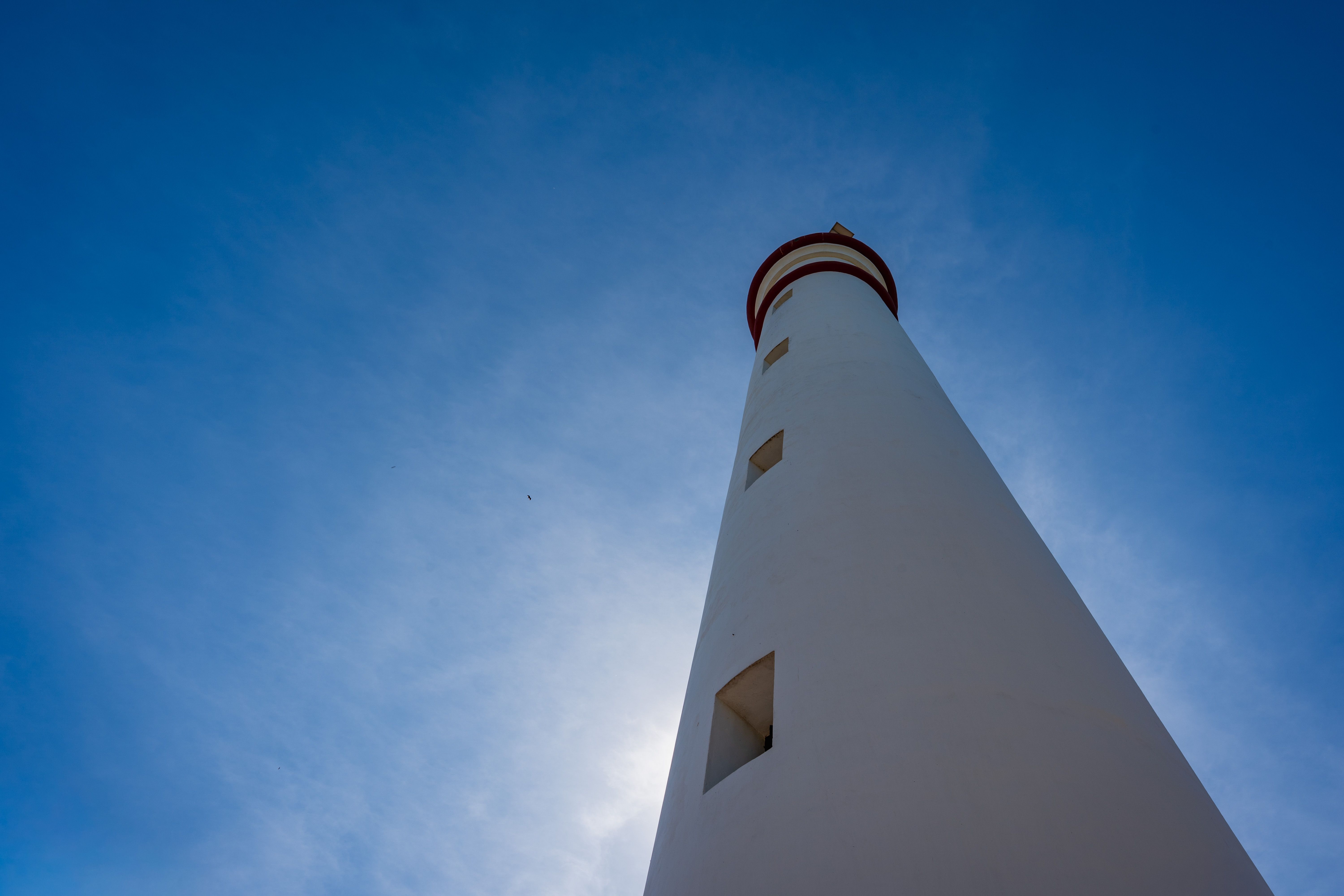 A stunning view of a tall lighthouse set against a vibrant blue sky in Batticaloa, Sri Lanka.