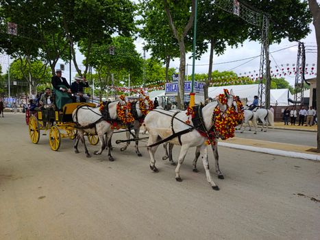 A decorated horse-drawn carriage at a vibrant Andalusian fair in El Puerto de Santa María.