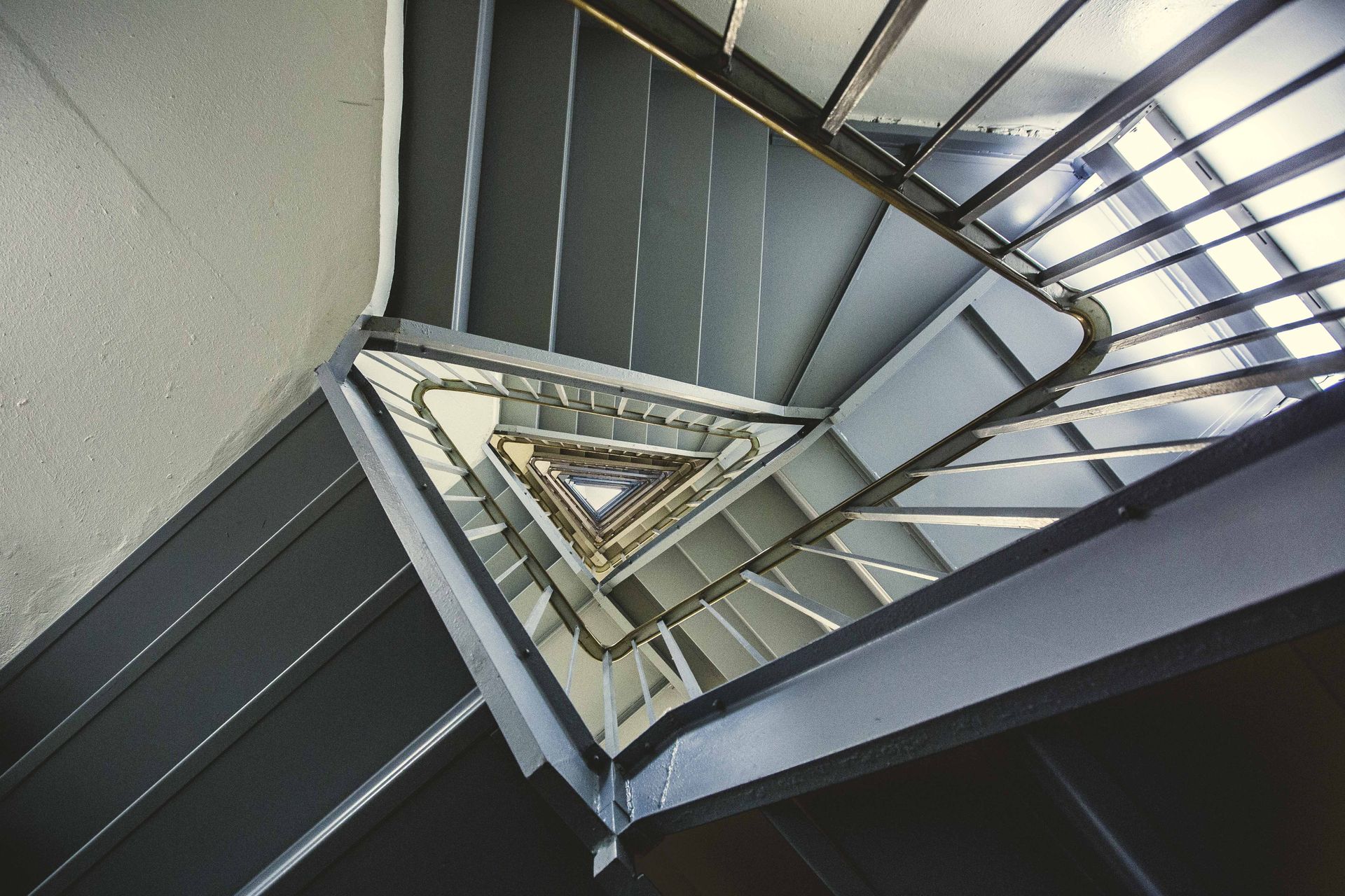 Abstract view of a modern spiral staircase capturing geometric patterns and steel structure.