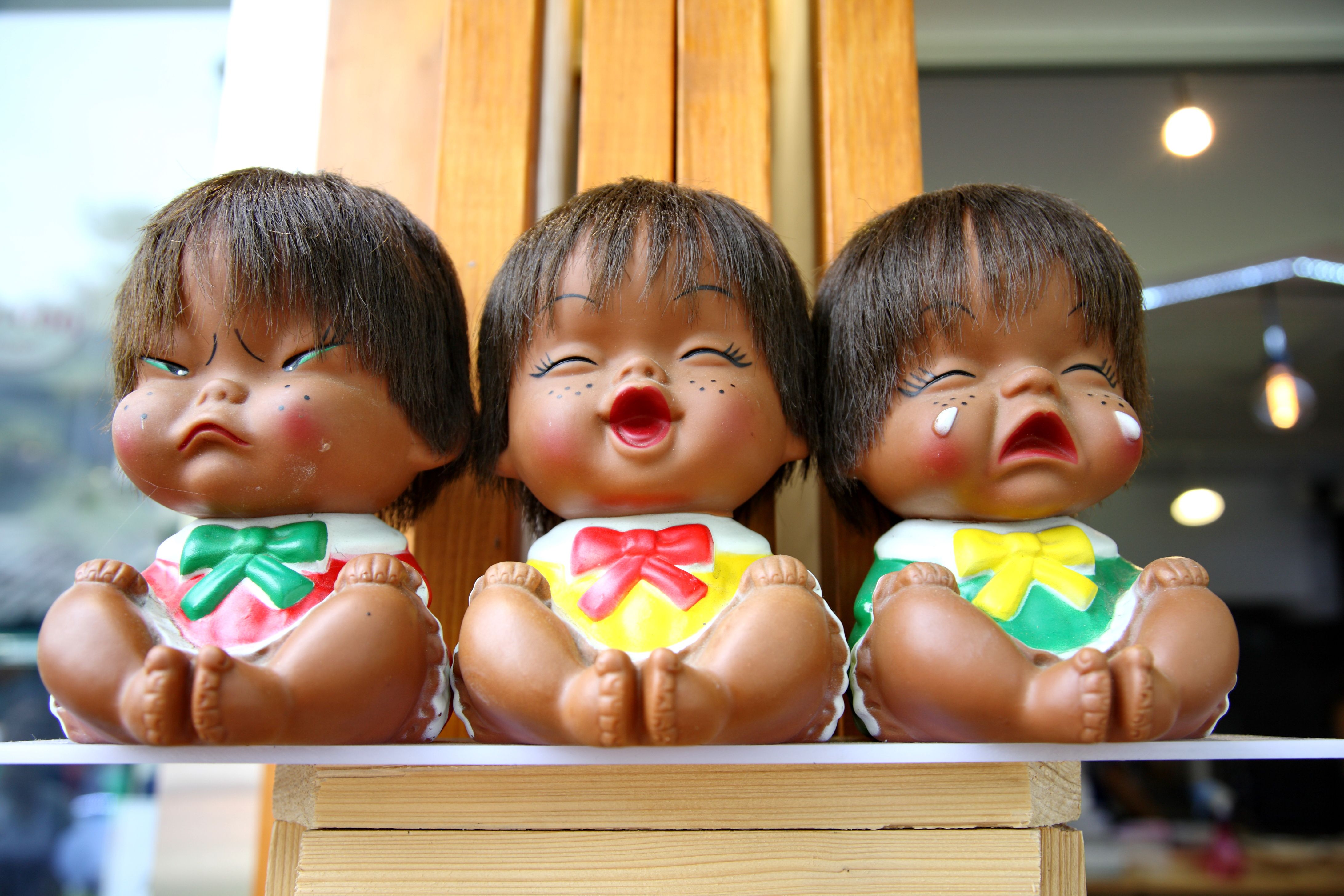 Tiga boneka mainan dengan ekspresi emosi yang berbeda