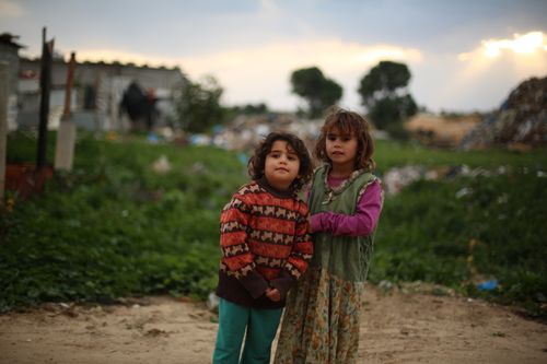 Free Two children stand outdoors in a rural area with a sunset backdrop. Stock Photo