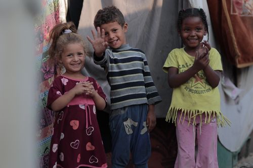 Free Group of happy children smiling and playing outdoors during the day. Stock Photo