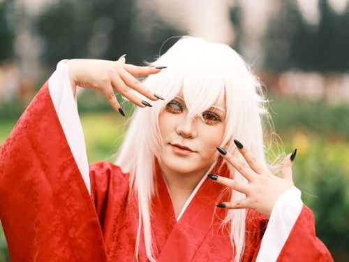 Free Person in cosplay with red robe and white wig posed outdoors in Vietnam garden setting. Stock Photo