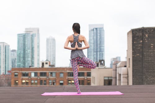 Woman Standing on Pink Yoga Mat Meditating