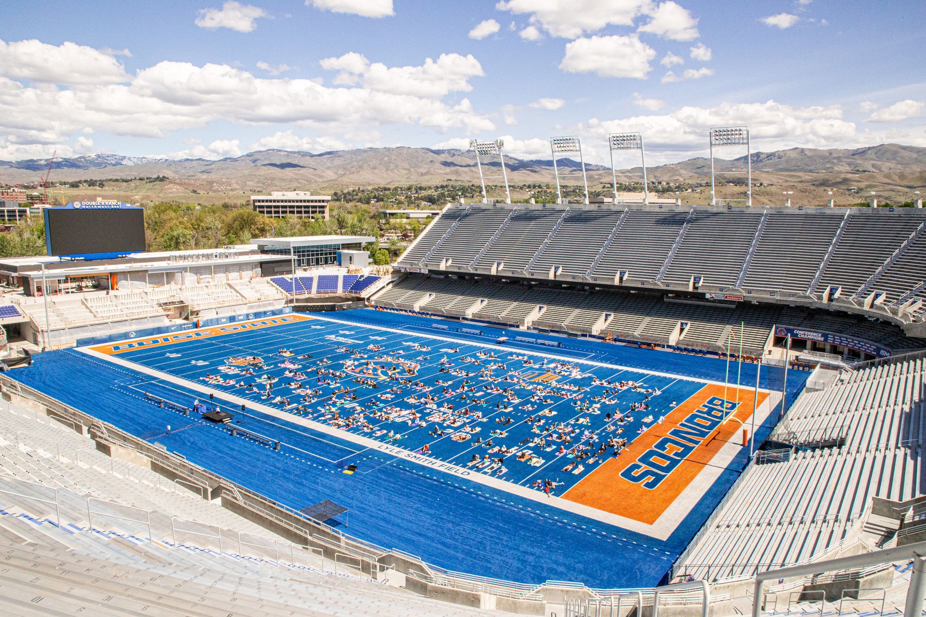 Aerial view of a yoga session taking place on the iconic blue turf of a stadium in Boise, Idaho.
