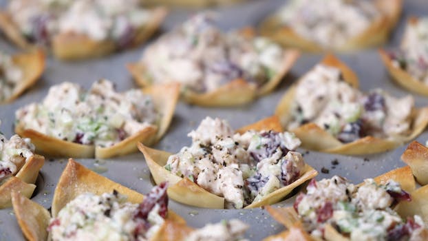 Delicious baked wonton appetizers filled with creamy chicken salad, perfect for serving at parties.