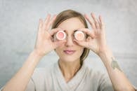 一名女子在室内开玩笑地拿着护肤霜罐