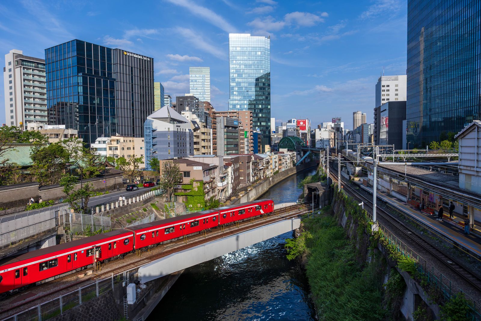 Tokyo red metro train over canal at dusk