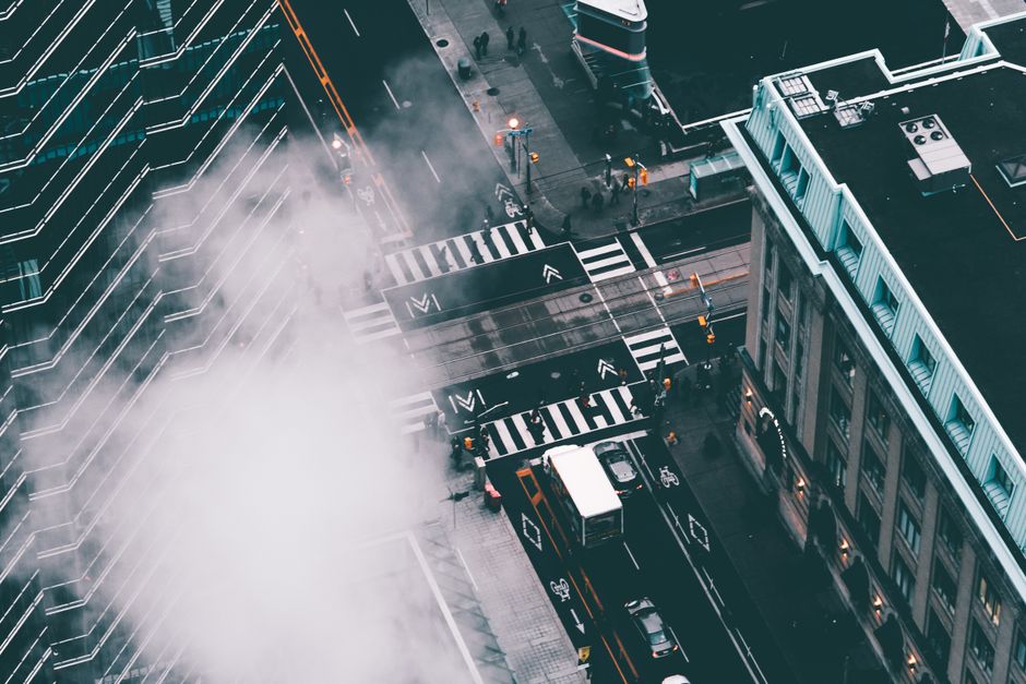 Dynamic cityscape showcasing a bustling intersection with traffic and pedestrians from above.