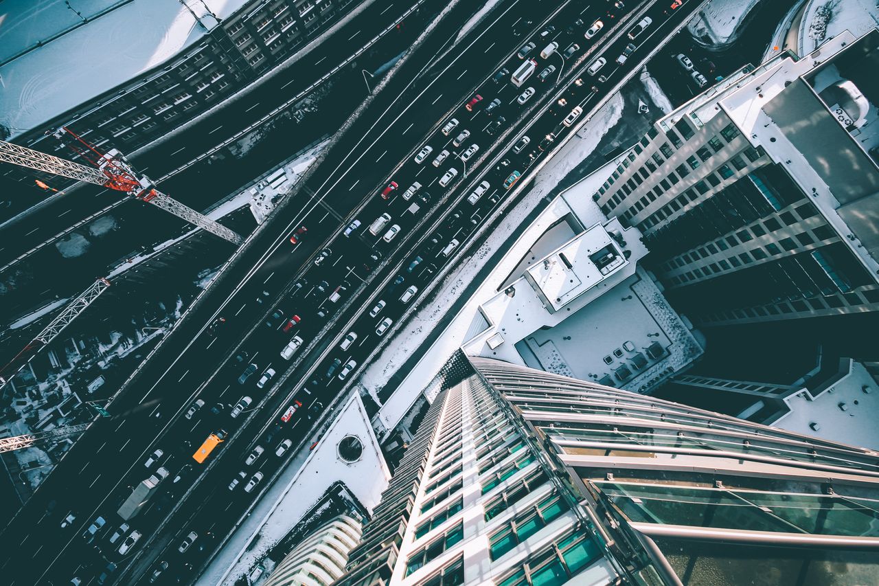 top down view of city streets with traffic and skyscrapers in an urban