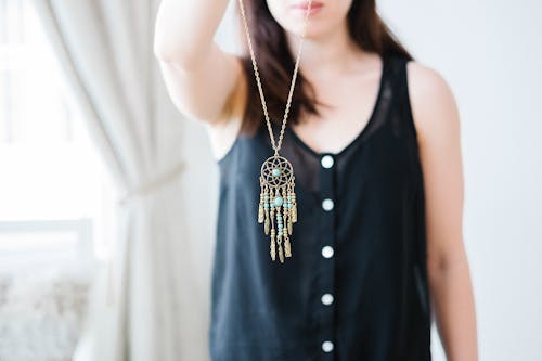 Free Woman Holding Necklace With Gold-colored Pendant Stock Photo