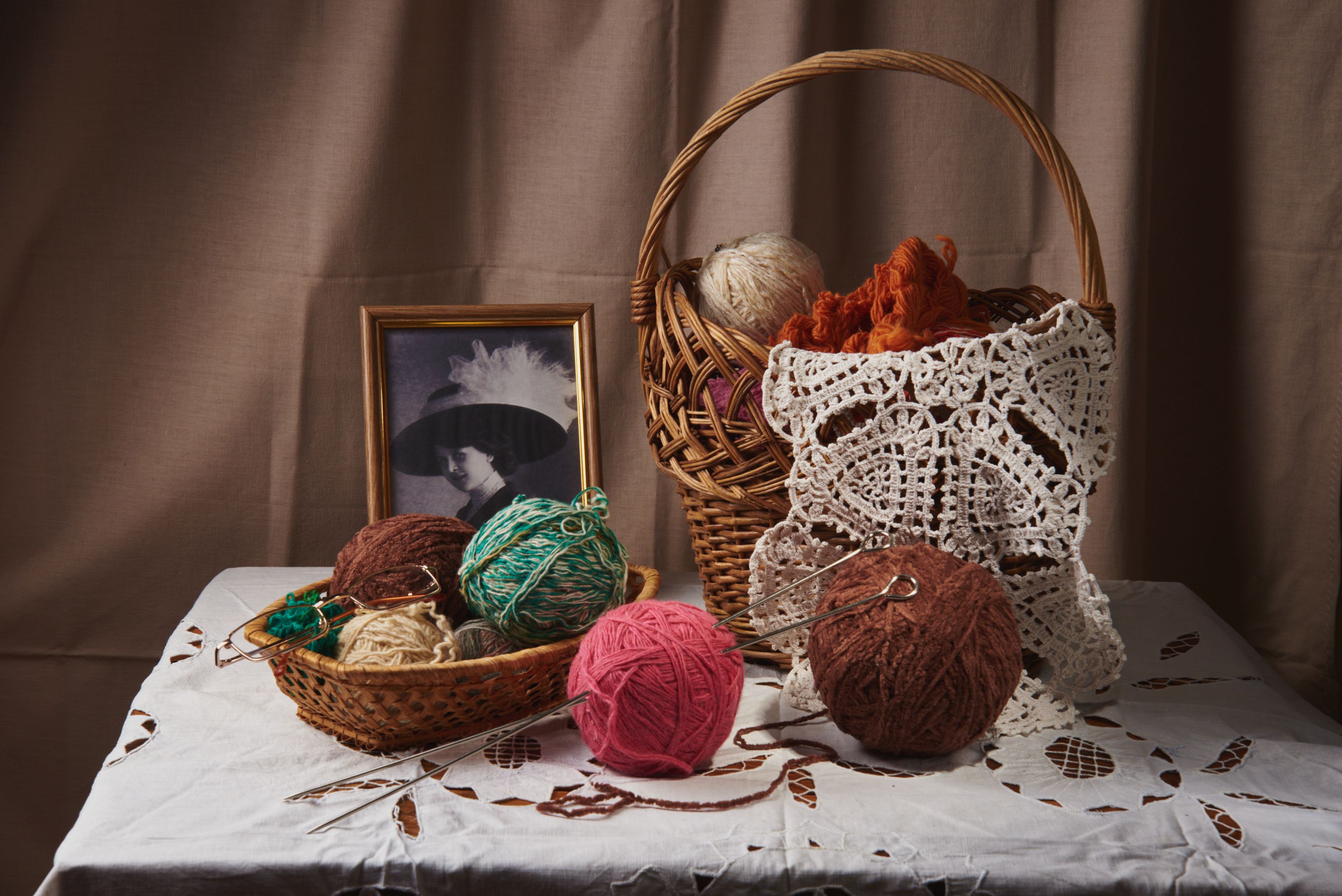 Knitting items on display at a colorful artisan market with wicker baskets and yarn