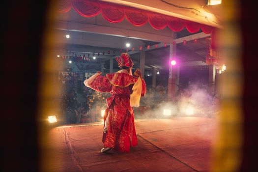 Colorful traditional dance performance featuring ornate costumes under warm stage lighting.