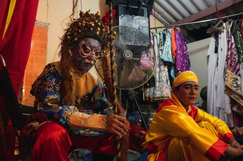 Free Two Chinese opera performers in ornate costumes preparing backstage before a performance. Stock Photo