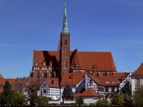 Free Historic architecture of Wrocław's cathedral under a clear blue sky, showcasing medieval design. Stock Photo
