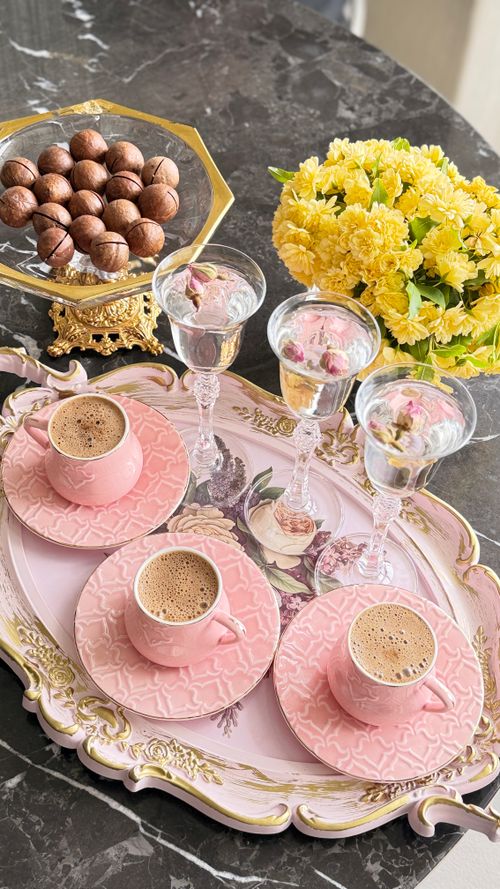 Free Luxurious coffee setup with pink cups on a floral tray beside yellow flowers. Stock Photo
