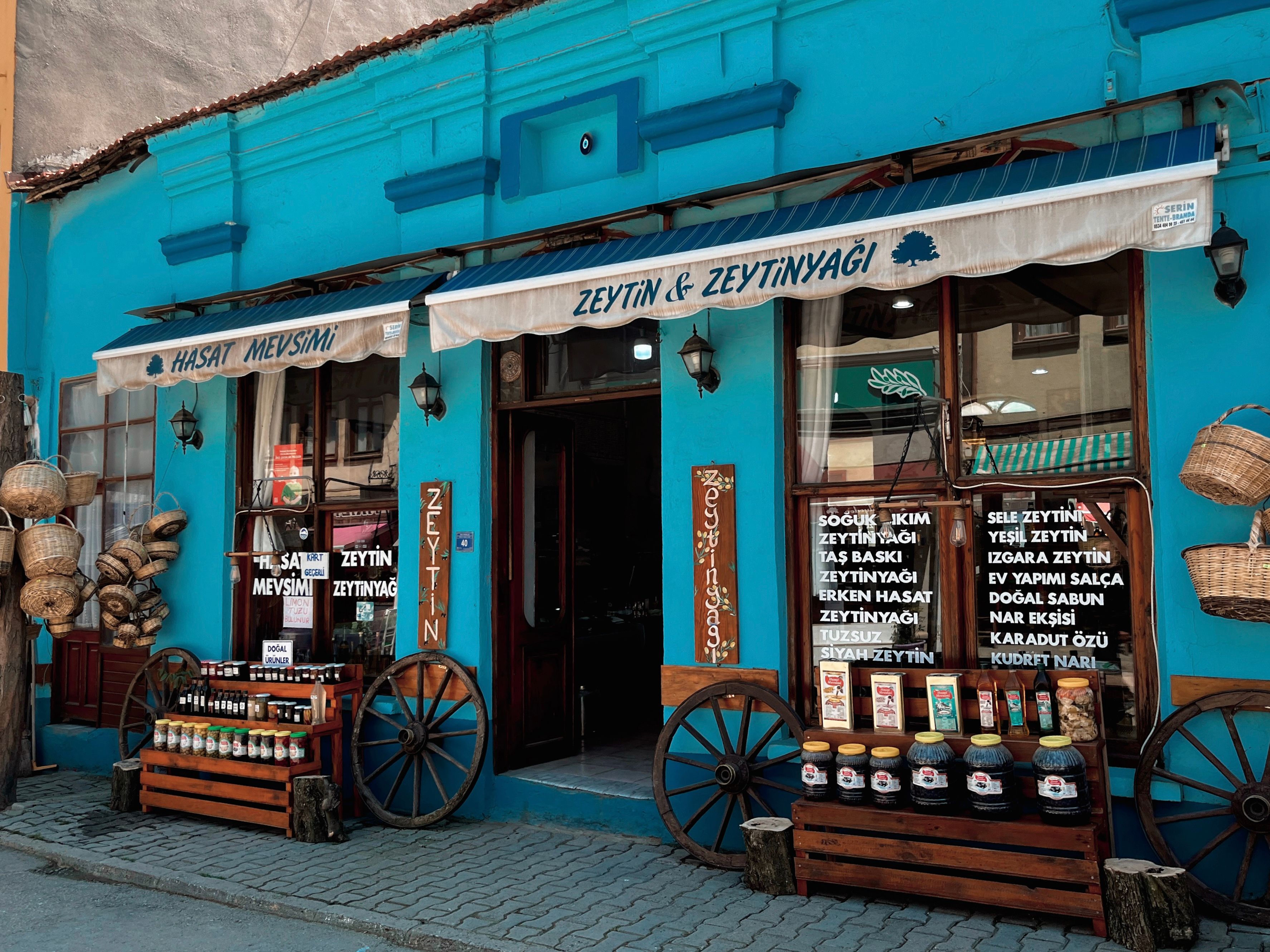 Vibrant blue storefront of an olive oil shop in Turkey with traditional decor.