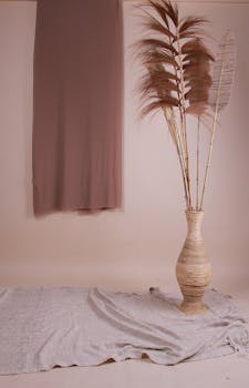 Elegant minimalist decor featuring pampas grass in a wicker vase against a neutral backdrop.